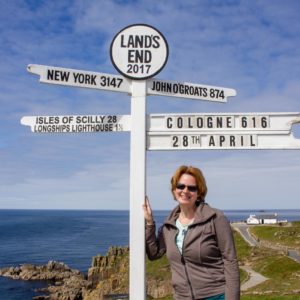 Alleine am Richtungsweiser von Land's End mit Schildern für New Yrk, John O'Groats, Isles of Scilly und Cologne